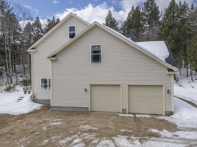 view of snowy exterior featuring a garage