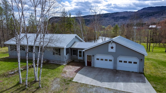 view of front of house with a mountain view, a garage, and a front lawn