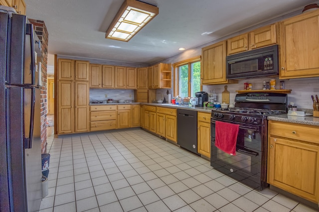 kitchen featuring decorative backsplash, sink, light tile patterned flooring, and black appliances