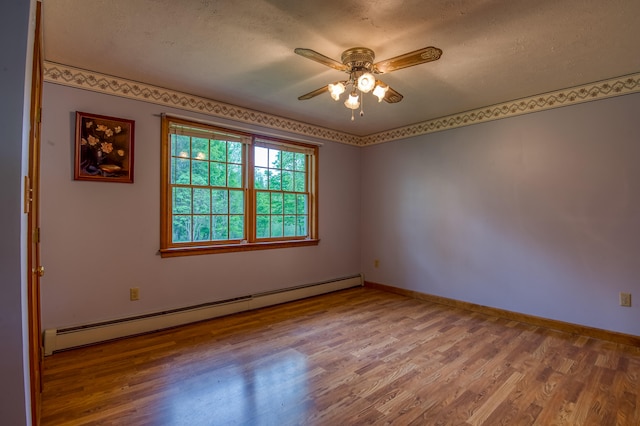 spare room featuring hardwood / wood-style floors, a textured ceiling, ceiling fan, and a baseboard heating unit