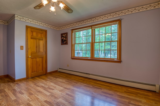 unfurnished bedroom featuring ceiling fan, baseboard heating, and light hardwood / wood-style flooring