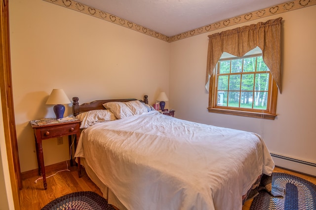 bedroom with wood-type flooring and a baseboard radiator