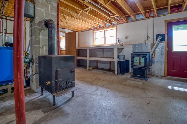 basement featuring plenty of natural light and a wood stove