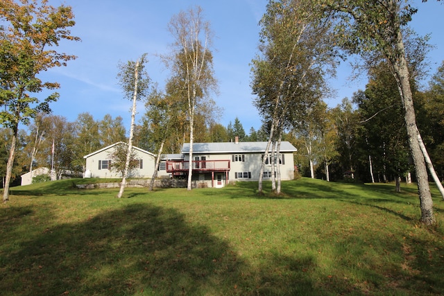 rear view of property featuring a lawn and a wooden deck