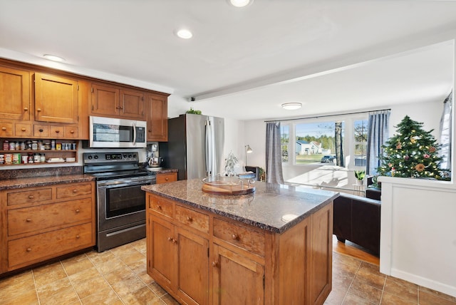 kitchen featuring a center island, stainless steel appliances, and dark stone counters