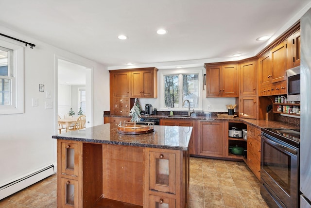 kitchen with a baseboard heating unit, sink, dark stone countertops, a center island, and black / electric stove