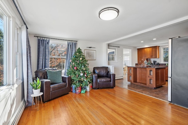 living area featuring baseboard heating and light hardwood / wood-style floors