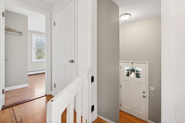 foyer entrance with a baseboard radiator and light wood-type flooring