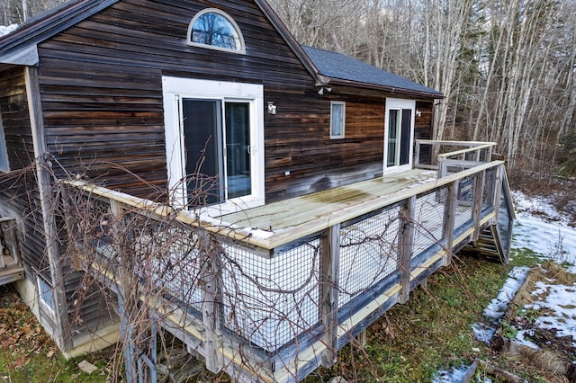 snow covered house featuring a wooden deck