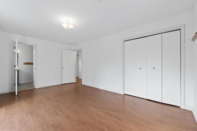 unfurnished bedroom featuring light wood-type flooring and a closet