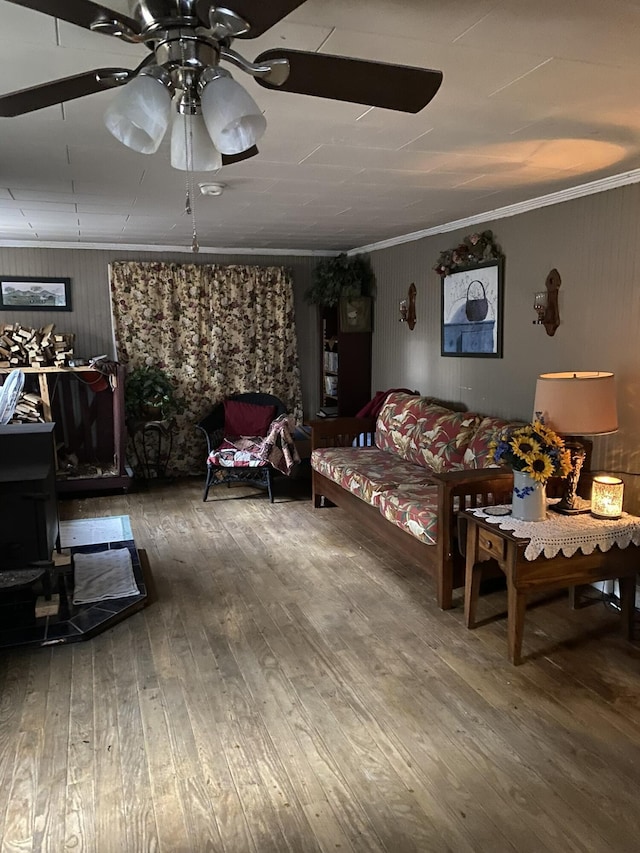 living room with ceiling fan, wood-type flooring, and ornamental molding