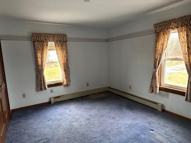 spare room featuring carpet flooring and a baseboard radiator