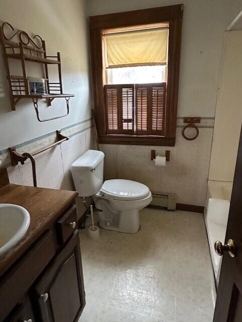 bathroom with vanity, toilet, tile walls, and a baseboard heating unit