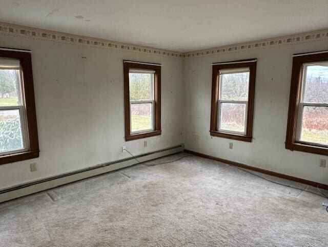 carpeted empty room featuring a baseboard radiator