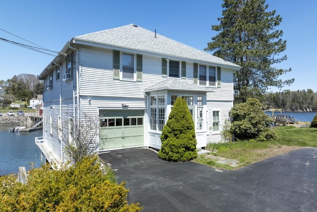 view of front facade featuring a garage and a water view