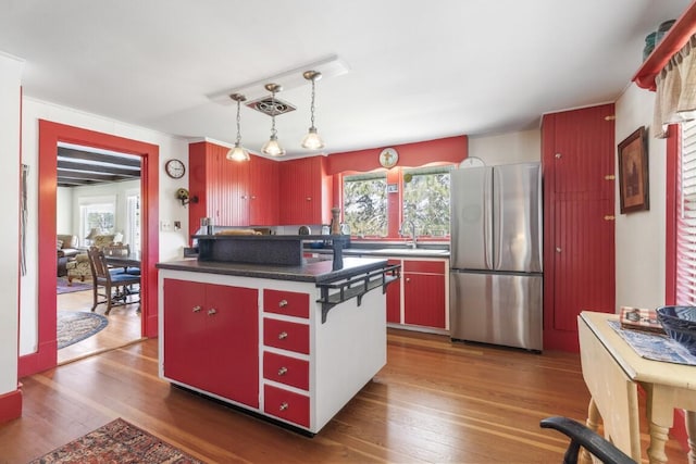 kitchen with stainless steel fridge, a center island, dark hardwood / wood-style floors, and a wealth of natural light