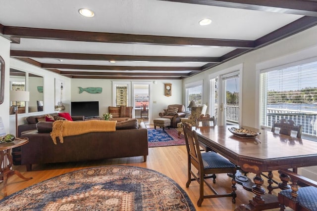 living room featuring beamed ceiling and light wood-type flooring