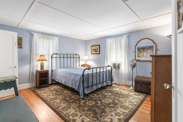 bedroom featuring hardwood / wood-style floors and a drop ceiling