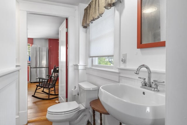 bathroom with toilet, hardwood / wood-style floors, and sink