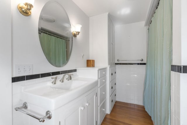 bathroom featuring vanity, tile walls, and hardwood / wood-style flooring