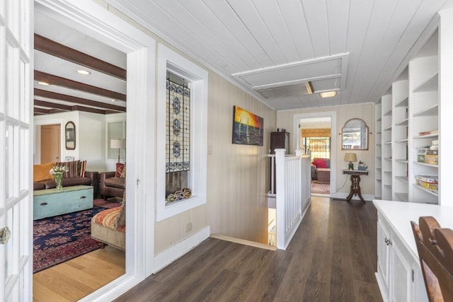 corridor with beamed ceiling, dark hardwood / wood-style floors, and wooden walls