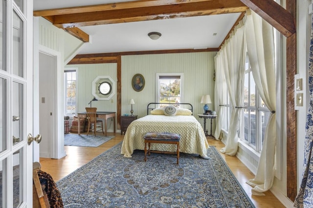 bedroom featuring light hardwood / wood-style flooring and beamed ceiling