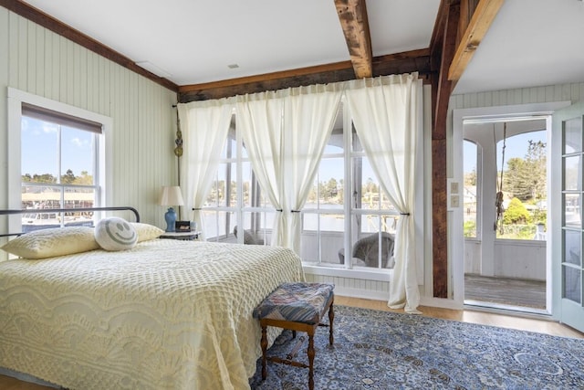 bedroom featuring access to exterior, hardwood / wood-style floors, and beamed ceiling