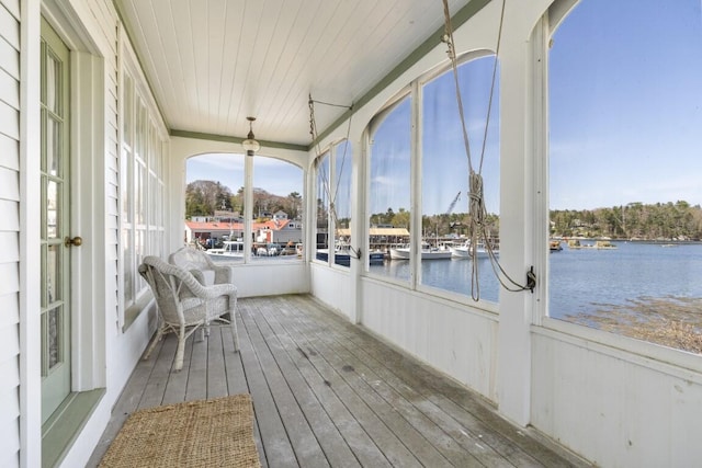 unfurnished sunroom featuring a water view