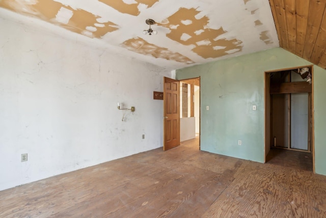 spare room featuring lofted ceiling and hardwood / wood-style flooring