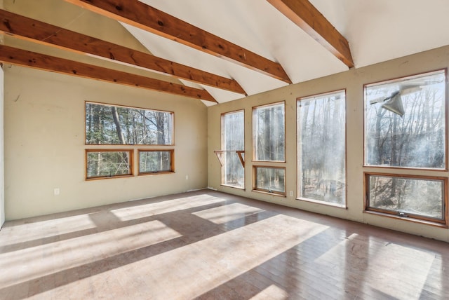 unfurnished sunroom featuring vaulted ceiling with beams