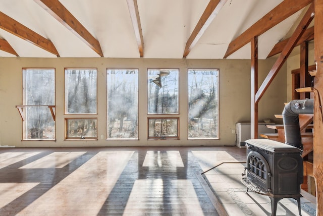 sunroom featuring vaulted ceiling with beams and a wood stove