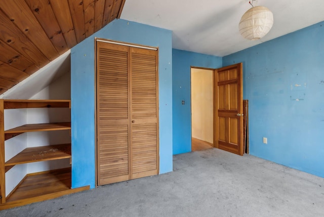 unfurnished bedroom featuring a closet, wood ceiling, and light colored carpet