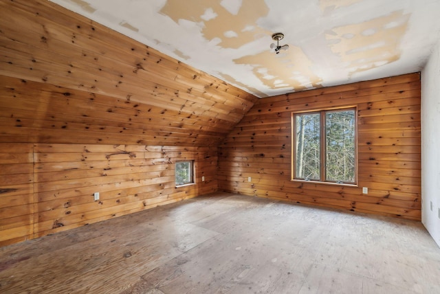 additional living space with lofted ceiling and wooden walls