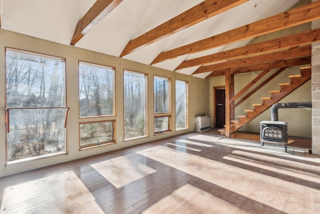 unfurnished sunroom with lofted ceiling with beams and a wood stove