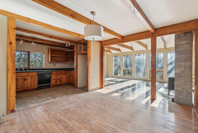 kitchen with dishwasher, hanging light fixtures, a wood stove, beam ceiling, and sink