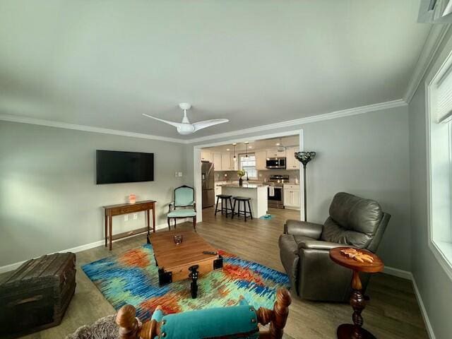 living room featuring hardwood / wood-style floors, a healthy amount of sunlight, and ornamental molding