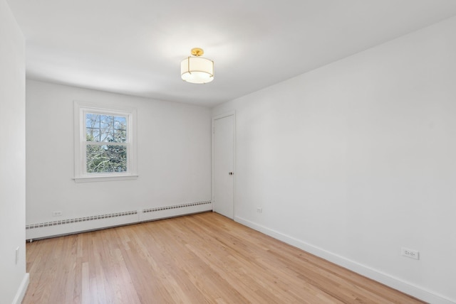 spare room featuring light wood-type flooring and a baseboard radiator