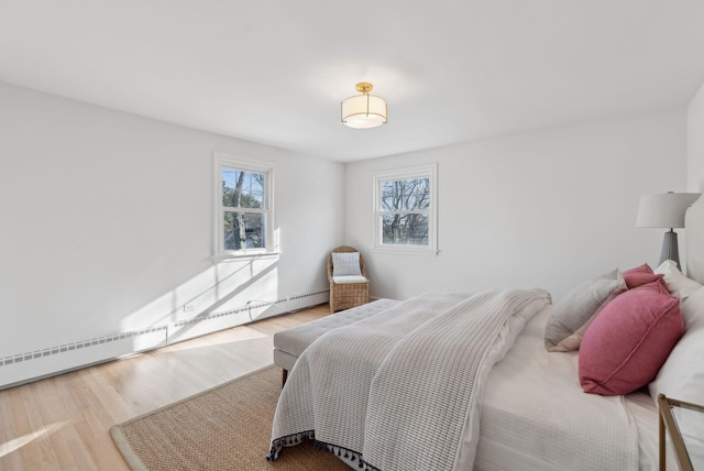 bedroom featuring a baseboard radiator and light hardwood / wood-style flooring