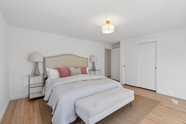 bedroom with light wood-type flooring and a closet