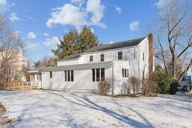 view of snow covered back of property