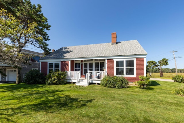 rear view of house with a lawn and a porch