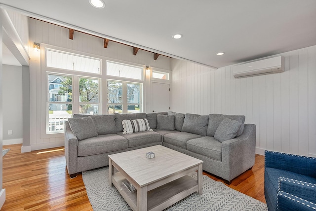 living room featuring hardwood / wood-style flooring, a wall mounted AC, and wood walls