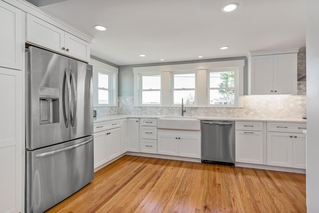 kitchen featuring white cabinets, stainless steel appliances, and light hardwood / wood-style floors