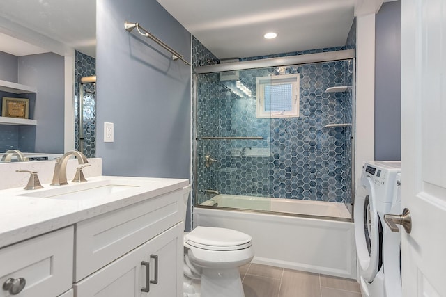 full bathroom with vanity, tile patterned floors, combined bath / shower with glass door, toilet, and independent washer and dryer