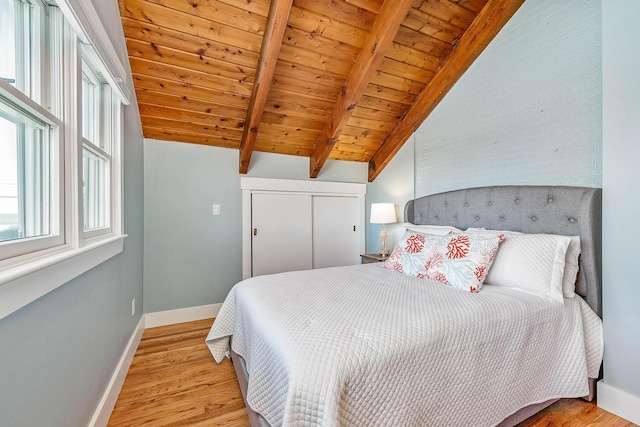 bedroom featuring vaulted ceiling with beams, light wood-type flooring, and wooden ceiling