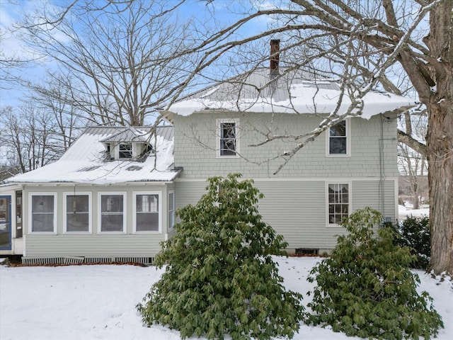 snow covered property featuring a sunroom