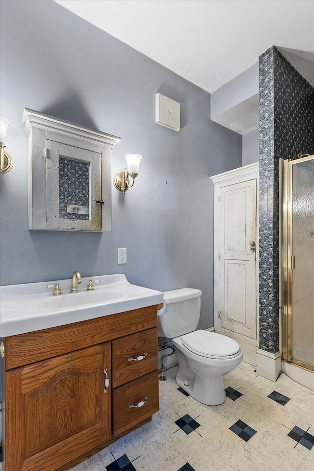 bathroom featuring vanity, an enclosed shower, and toilet