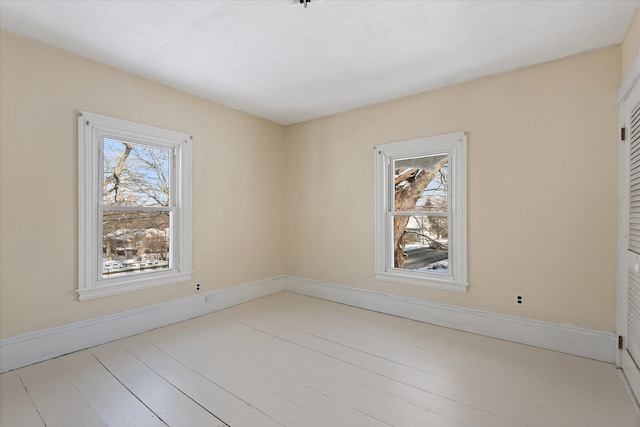 spare room with plenty of natural light and light hardwood / wood-style flooring