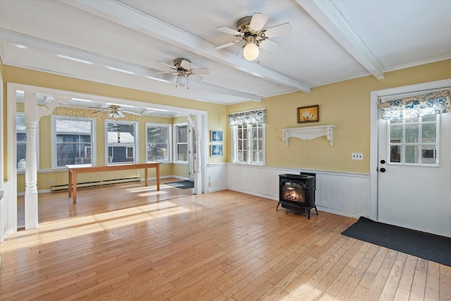 entrance foyer with a wood stove, light hardwood / wood-style flooring, ceiling fan, baseboard heating, and beamed ceiling