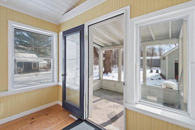 entryway featuring wood walls, a healthy amount of sunlight, and hardwood / wood-style flooring